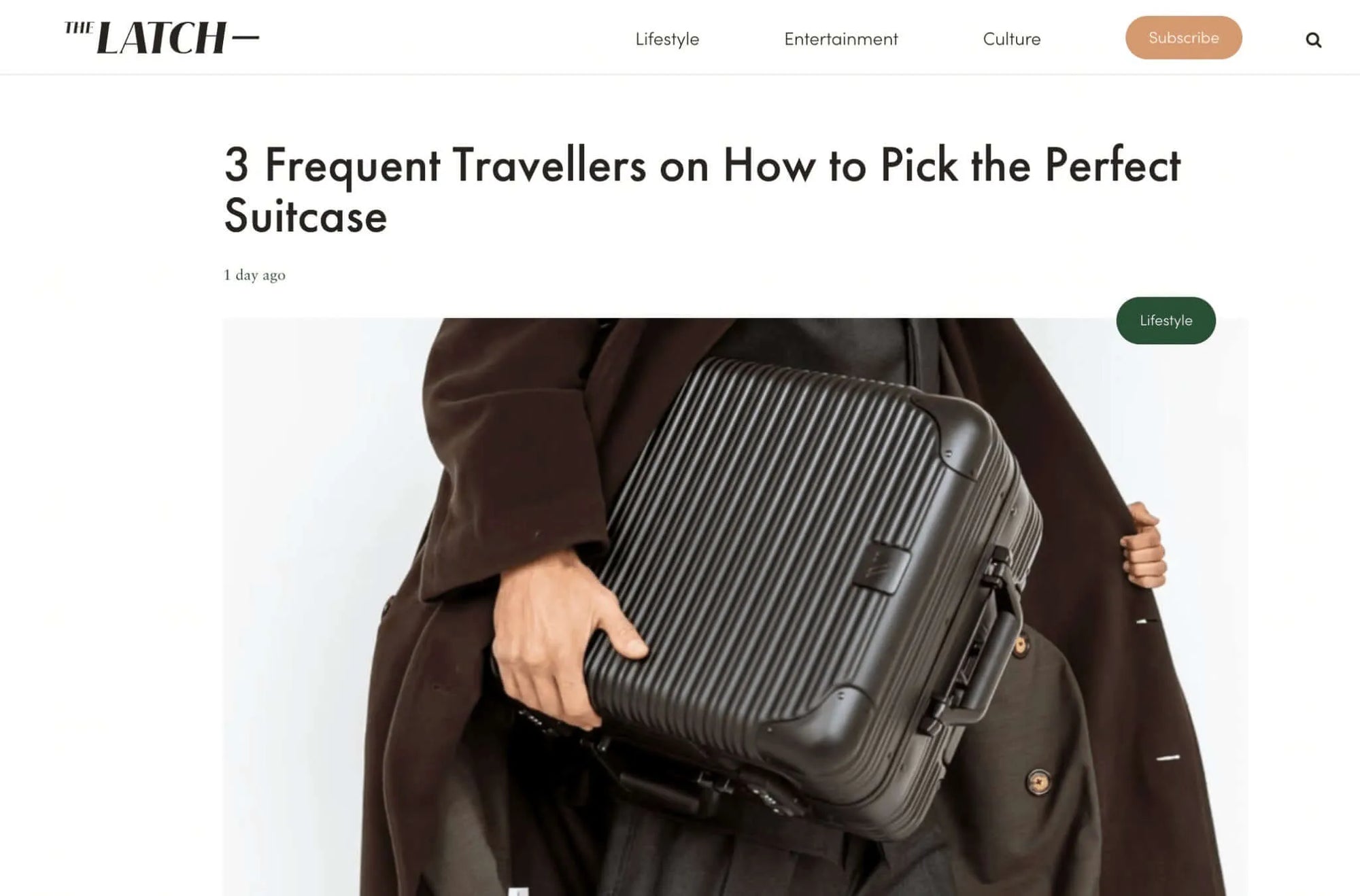 Person holding a sleek black suitcase, featured in The Latch article on selecting the perfect travel suitcase.