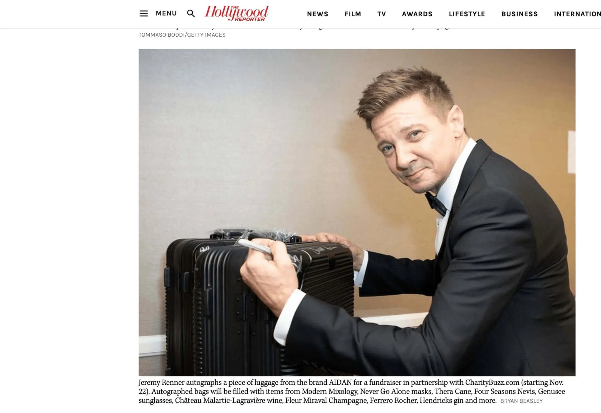 Jeremy Renner autographs an AIDAN suitcase for a CharityBuzz fundraiser at The American Cinematheque Gala.
